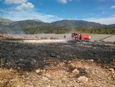 Bomberos del CEIS y agente medioambiental apagan una quema de plásticos junto al monte, en Aledo