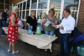 Socios y usuarios del Centro Municipal de Personas Mayores de la plaza Balsa Vieja disfrutan del reparto de agua limón con motivo de las fiestas