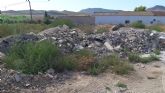 Toneladas de escombro procedente de obras municipales se acumula desde hace 10 meses en un vertedero ilegal a la entrada de la pedanía de Doña Inés