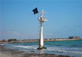 Ecologistas en Acción protesta en la Playa de La Llana colocando una bandera negra