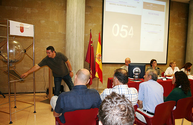 La directora gerente del Instituto de Vivienda y Suelo, Juana Castaño (en la mesa, segunda por la izquierda), junto al notario que dio fe de la celebración del sorteo público, Foto 1