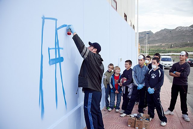 Los jóvenes, inscritos en el ‘Taller de Grafiti’, ya han empezado a pintar el que será el gran grafiti del Pabellón de Deportes de La Cañadica, Foto 1