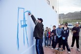 Los jóvenes, inscritos en el ‘Taller de Grafiti’, ya han empezado a pintar el que será el gran grafiti del Pabellón de Deportes de La Cañadica