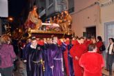 Anderos de diversas cofradías portan a hombros el trono de la Santa Cena