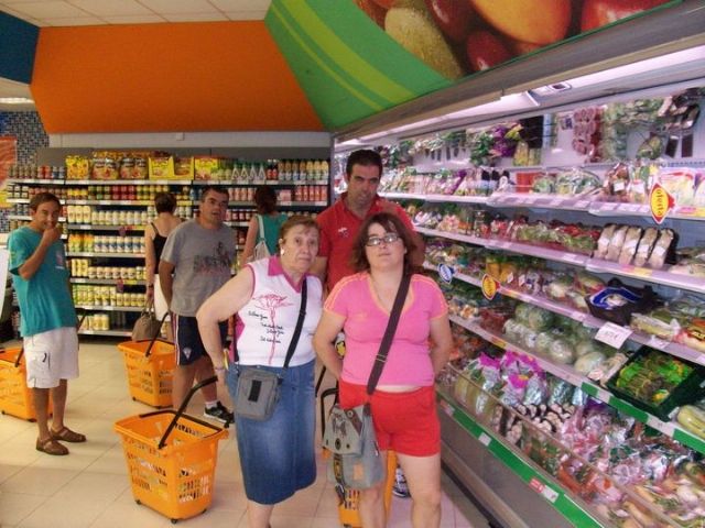Los usuarios del Centro de Día José Moya Trilla realizan una compra en un comercio del municipio para reforzar sus habilidades en la vida diaria, Foto 1