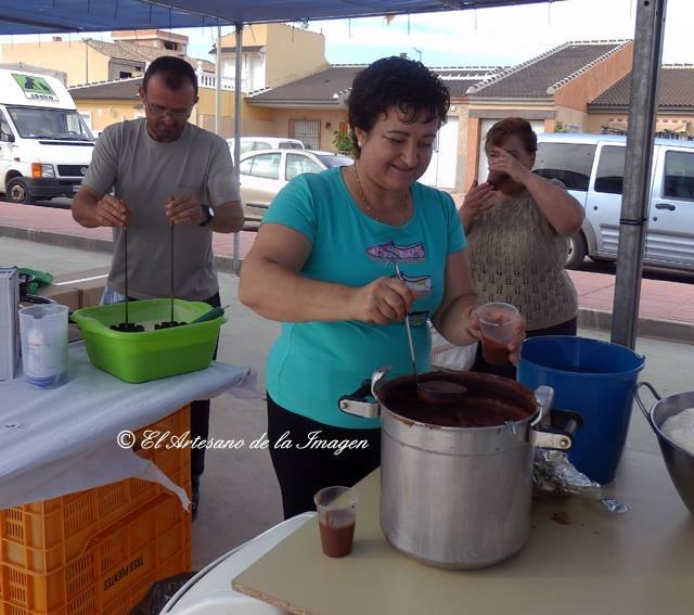 Soledad sirve chocolate a los trilladores y vecinos, mientras un vecino artesano realiza flores, Foto 2
