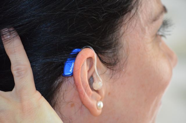 Una mujer se prueba el audífono, Foto 1