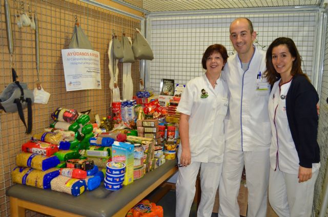 Rehabilitadores de Clínica Belén con parte de los alimentos recogidos, Foto 1