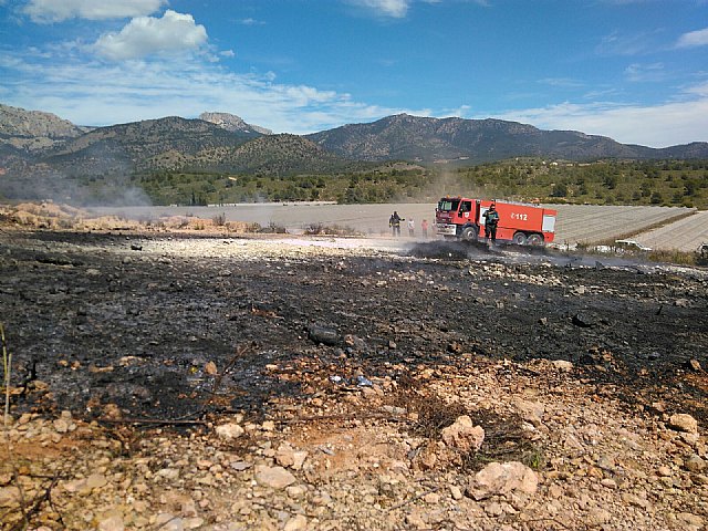 Bomberos del CEIS y agente medioambiental apagan una quema de plásticos junto al monte, en Aledo, Foto 1