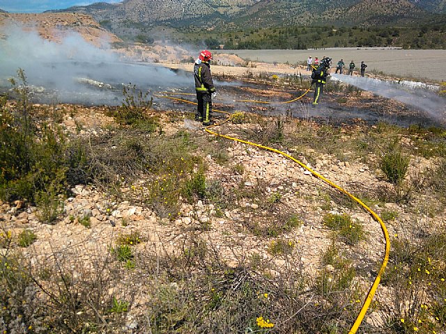 Bomberos del CEIS y agente medioambiental apagan una quema de plásticos junto al monte, en Aledo, Foto 2