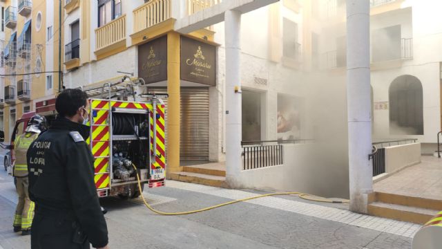 Efectivos de Policía Local y Bomberos de Lorca extinguen un pequeño incendio que se ha producido en un vehículo estacionado en un garaje de la calle Murillo - 1, Foto 1