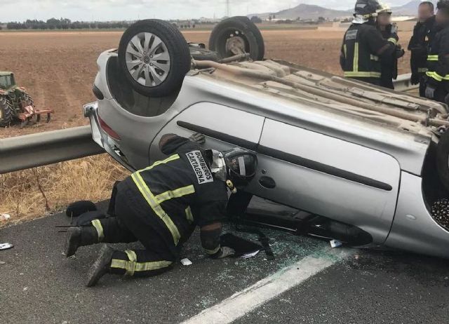 Los bomberos rescatan a una mujer embarazada cuyo vehiculo habia volcado en un accidente de trafico - 1, Foto 1