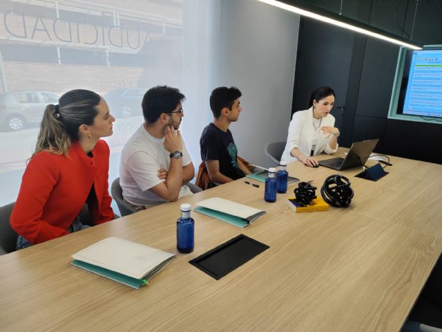 Tres alumnos atienden a las explicaciones de una profesional en una de las firmas de auditoría participantes., Foto 1