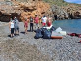 Personas voluntarias celebran el Día Internacional de Cruz Roja recogiendo residuos en las playas de Cabo de Palos, en Cartagena