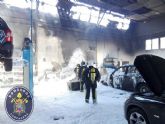 Bomberos y Policia Local intervienen en la extincion del incendio de un concesionario en la via rapida de La Manga