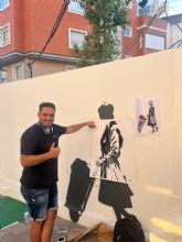 El artista urbano Alberto Len pinta un mural en Alcantarilla para apoyar al comercio local